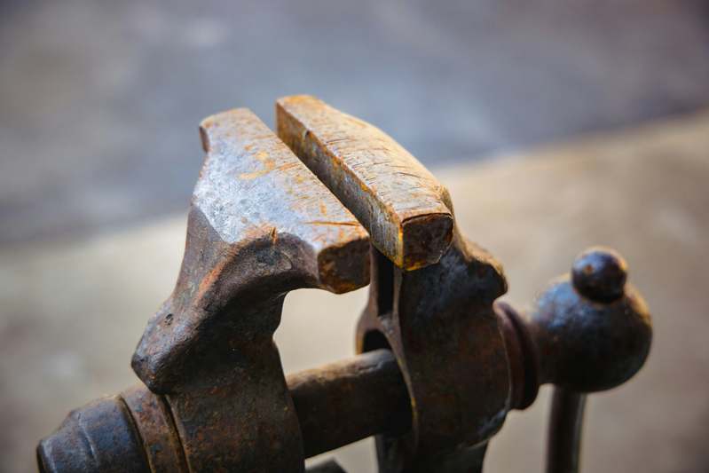 Close-up of various clamp types neatly arranged on metal shelving